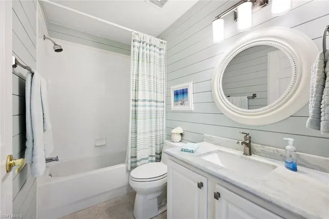 a bathroom with a granite countertop toilet sink and mirror