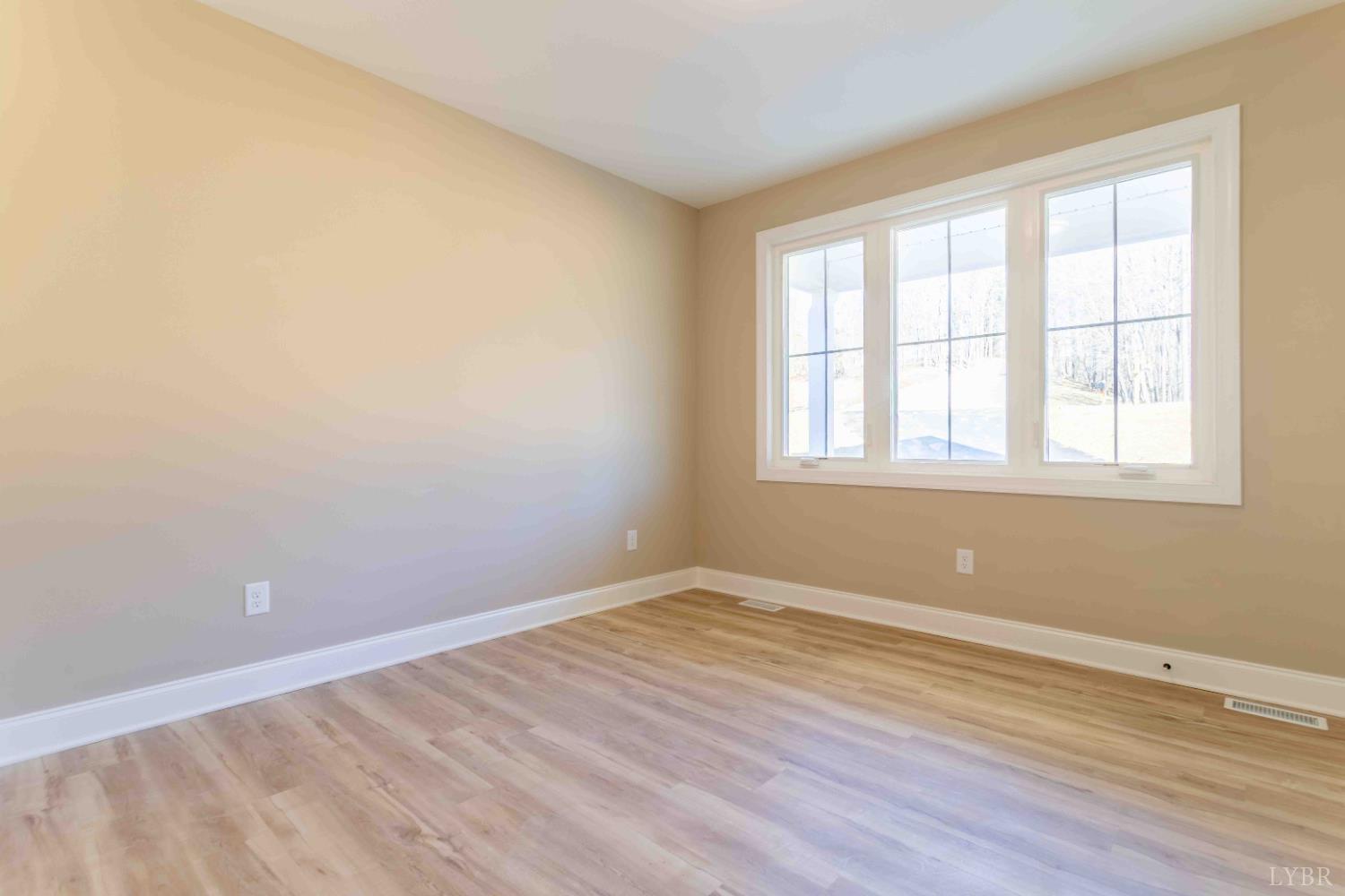 1115 Thornblade Way Blue Ridge, VA 24064 - Photo 17 of 44 an empty room with wooden floor and windows
