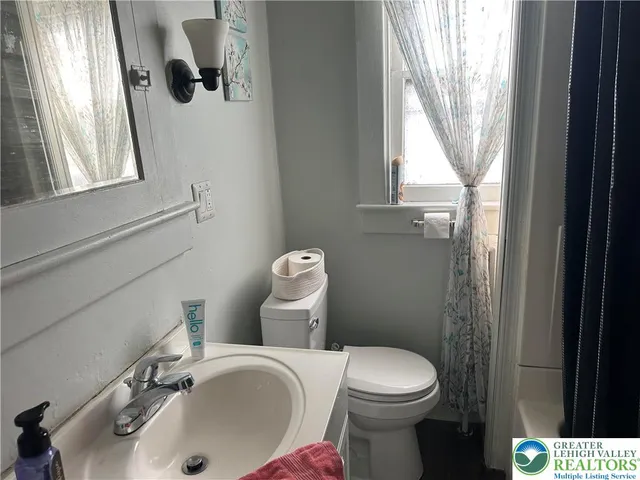 a bathroom with a sink a toilet and a window