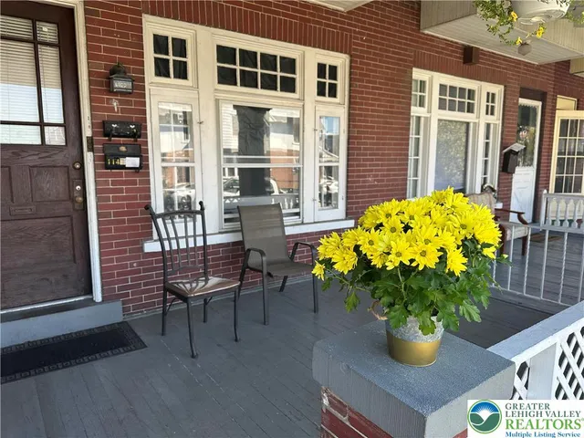 a vase of flowers sitting on a table in front of a house