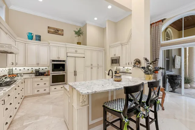 a kitchen with granite countertop white cabinets and stainless steel appliances