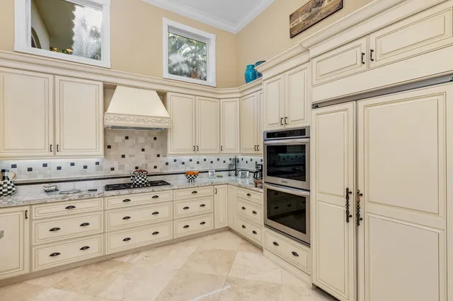 a large white kitchen with stainless steel appliances granite countertop a stove a sink and a microwave