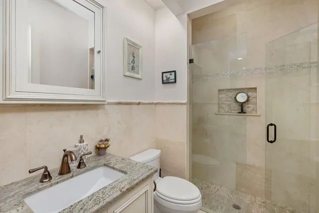 a front view of a house with a garden and lake view