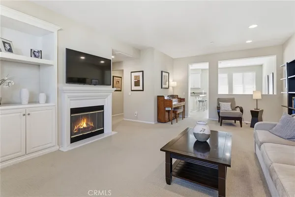 a living room with furniture a flat screen tv and a fireplace