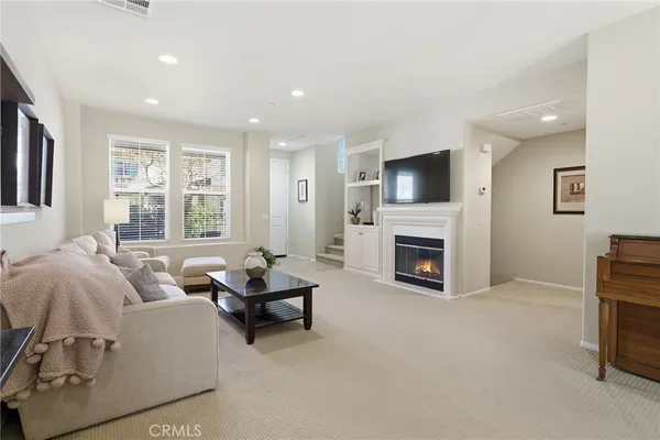 a living room with furniture a fireplace and a flat screen tv