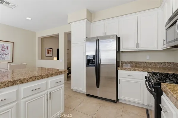 a kitchen with stainless steel appliances granite countertop a refrigerator and a stove