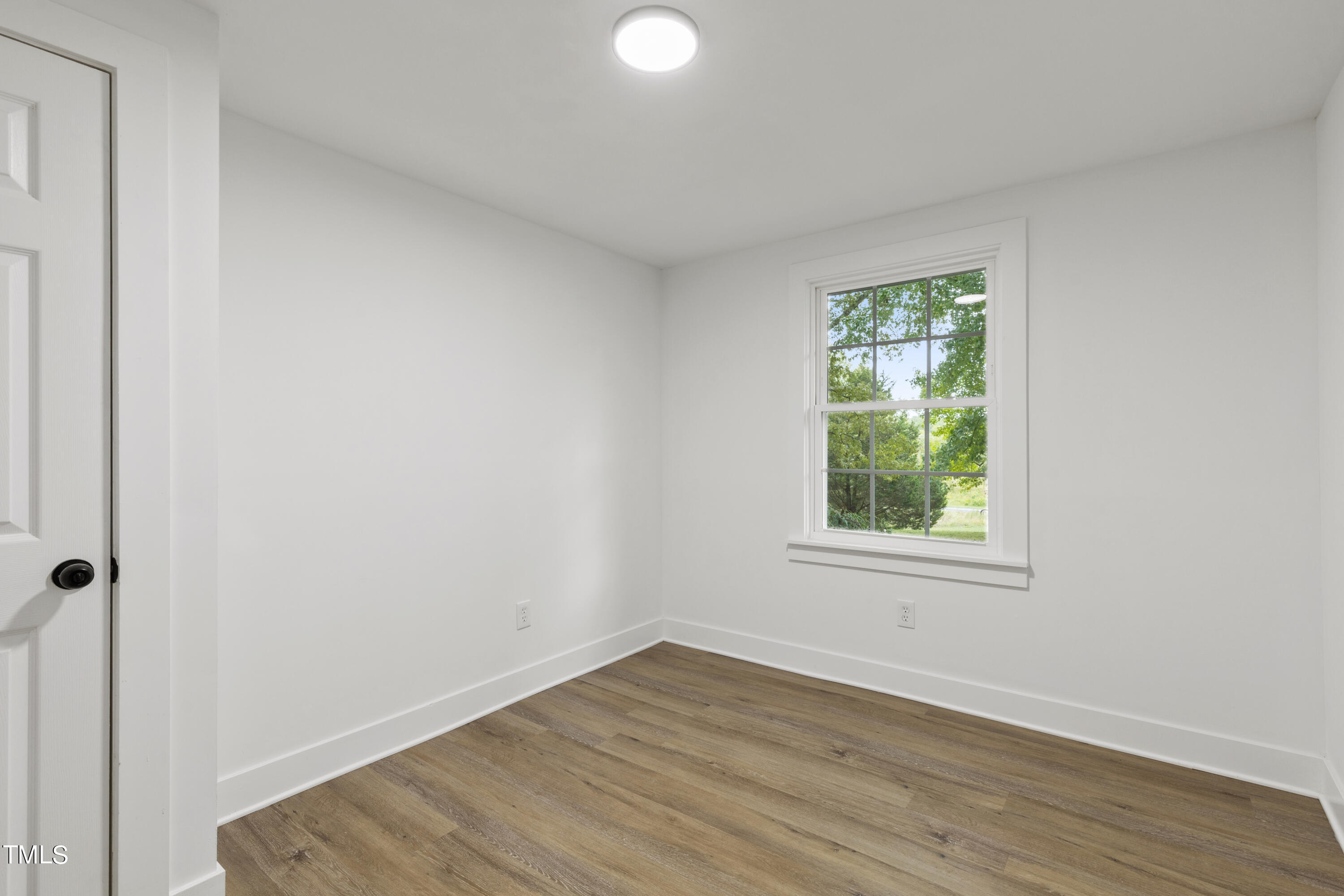 4721 Kimbro Road Hillsborough, NC 27278 - Photo 9 of 11 an empty room with wooden floor and windows