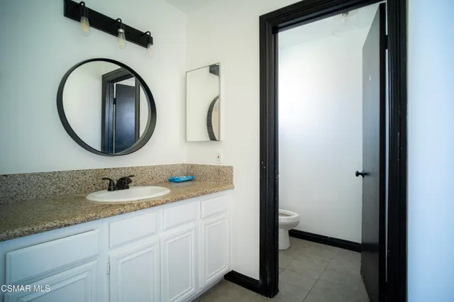 a bathroom with a granite countertop double vanity sink and a mirror