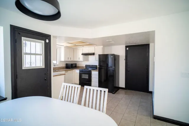 a kitchen with stainless steel appliances kitchen island granite countertop a refrigerator and a sink