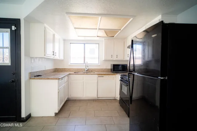 a kitchen with a refrigerator and a sink