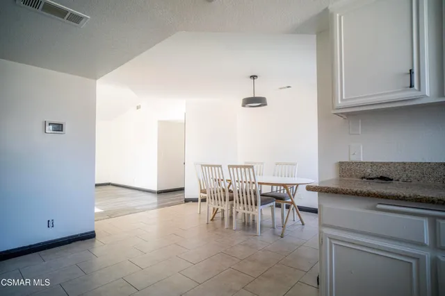a view of kitchen with granite countertop window and white cabinets