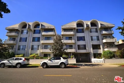a view of parking with cars parked in front of it