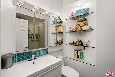a bathroom with a sink a toilet and a shower