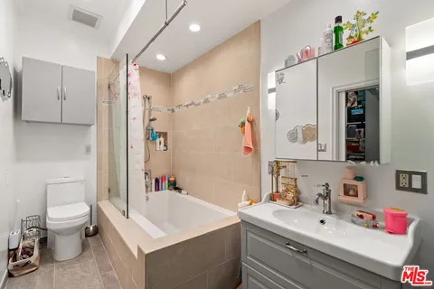 a bathroom with a sink vanity mirror and toilet