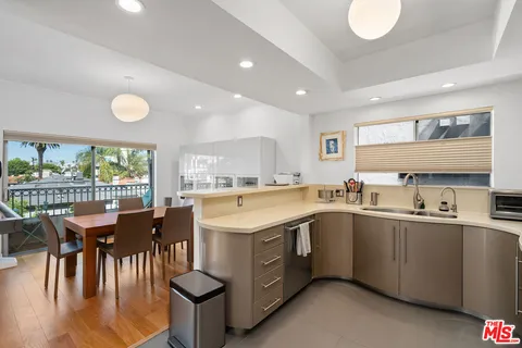 a kitchen with a sink a stove a dining table and chairs