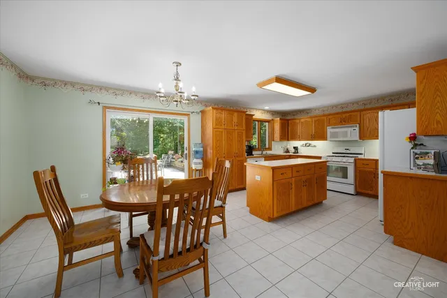 a dining room with furniture a kitchen view and a chandelier