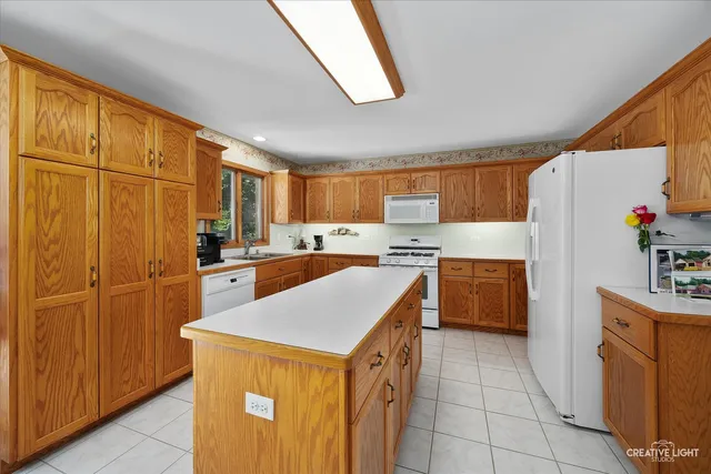 a kitchen with a refrigerator a sink dishwasher and a refrigerator with wooden cabinets