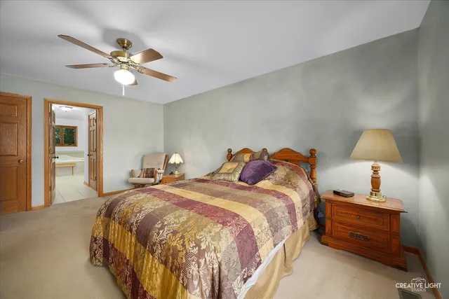 a spacious bedroom with a bed and a chandelier