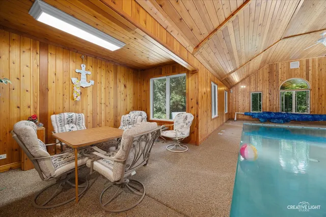 a dining room with furniture and a floor to ceiling window