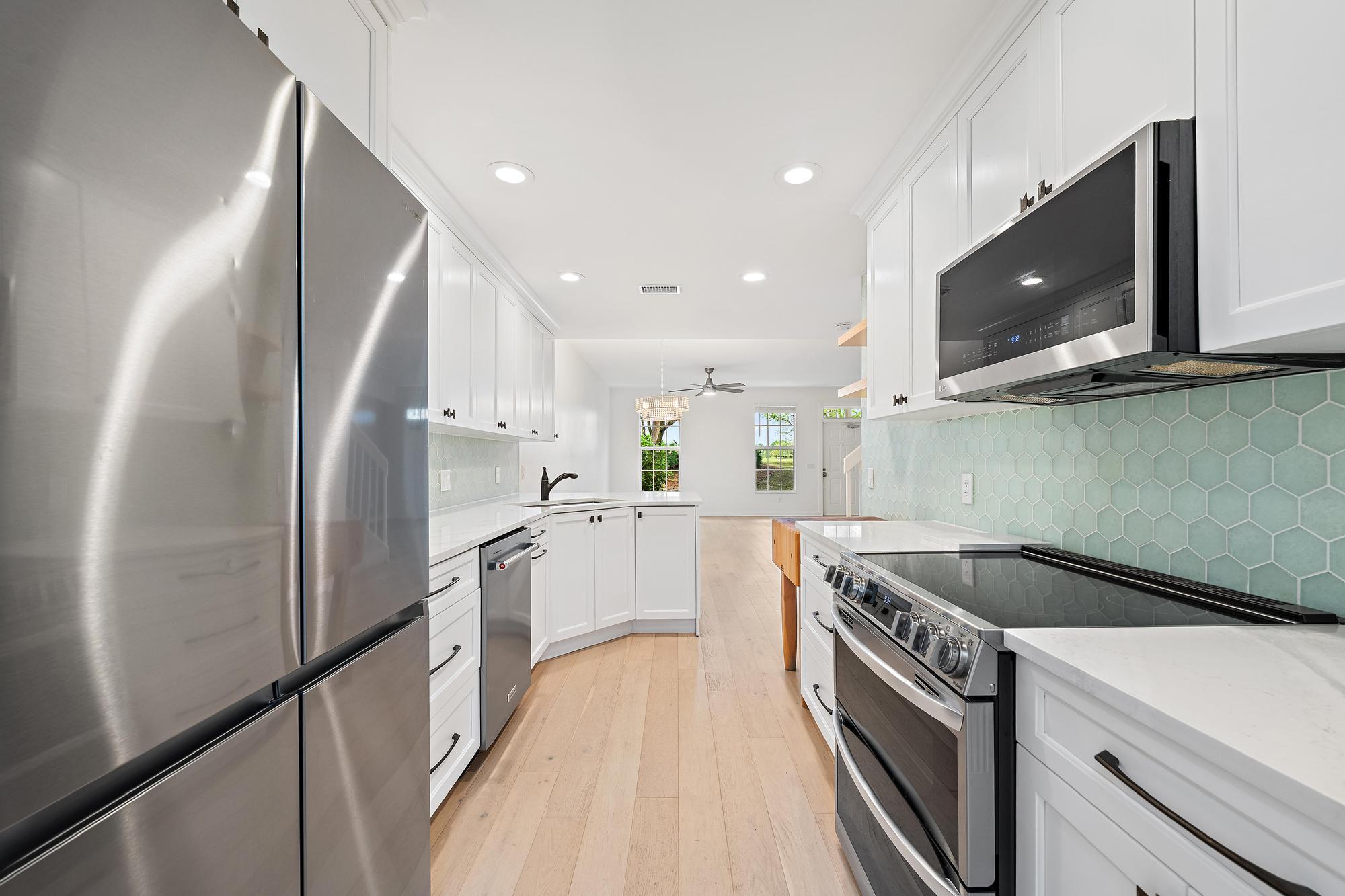 136 Ashley Court Jupiter, FL 33458 - Photo 9 of 26 a kitchen with stainless steel appliances granite countertop a sink a stove a microwave and a refrigerator