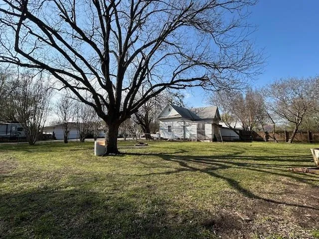 a view of a water fountain in front of a house with a yard