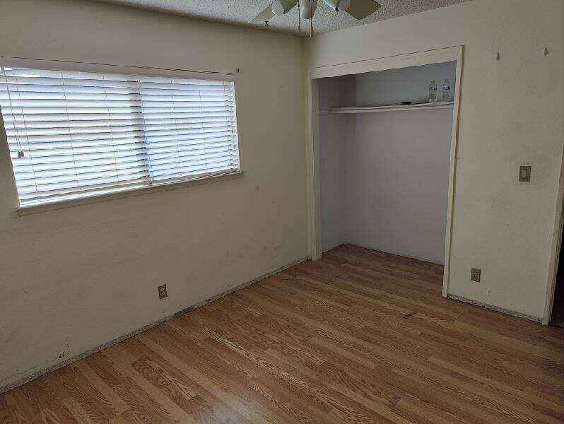 224 South Broadway Street Ridgecrest, CA 93555 - Photo 8 of 21 an empty room with wooden floor and windows