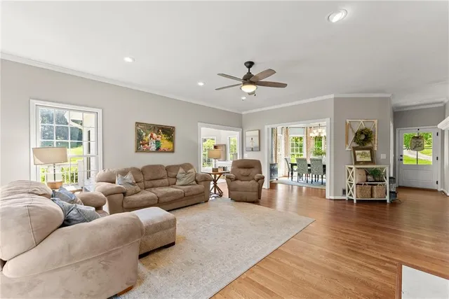 a living room with furniture flat screen tv and hard wood flooring
