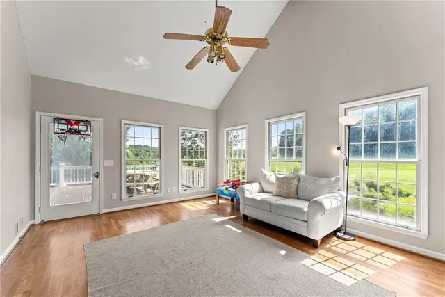 a living room with furniture floor to ceiling window and wooden floor