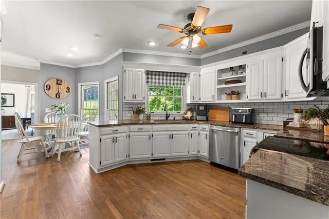 a kitchen with stainless steel appliances granite countertop a refrigerator and a stove top oven