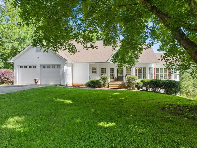 a front view of a house with a yard and trees