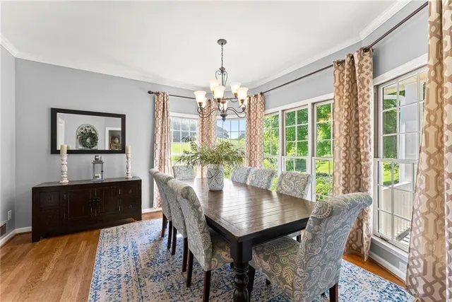 a view of a dining room with furniture a chandelier and wooden floor