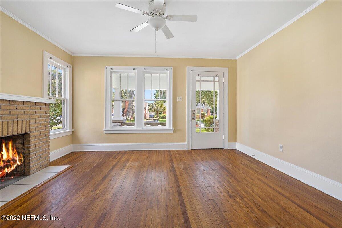 352 West 68th Street Jacksonville, FL 32208 - Photo 4 of 11 a view of an empty room with wooden floor fireplace and a window