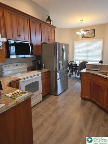 a kitchen with stainless steel appliances a sink a stove a refrigerator cabinets and a dining table