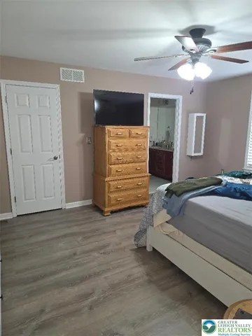 a spacious bedroom with a bed and a ceiling fan