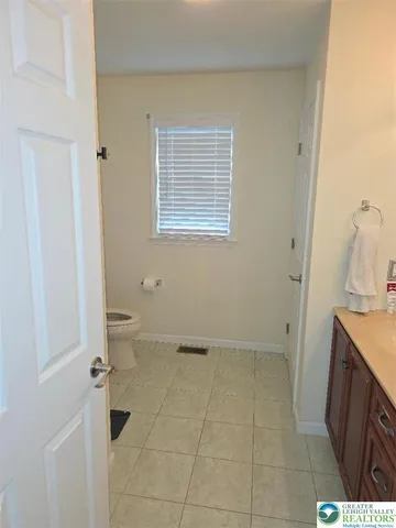 a bathroom with a granite countertop sink a toilet and a mirror