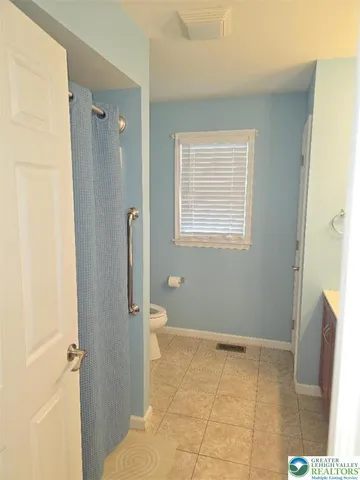 a bathroom with a granite countertop sink a toilet and a mirror