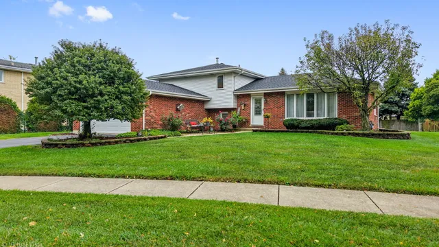 a front view of a house with a yard and trees