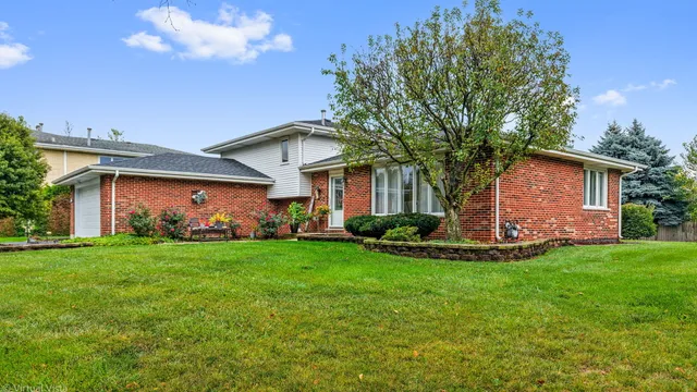 a front view of a house with a garden and yard