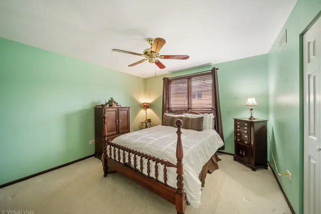 a bedroom with a bed chandelier and a window