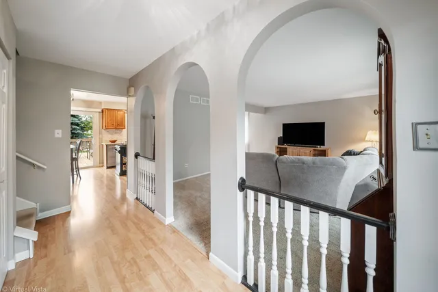 a view of a hallway with wooden floor and a living room