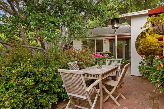a patio with table and chairs and potted plants