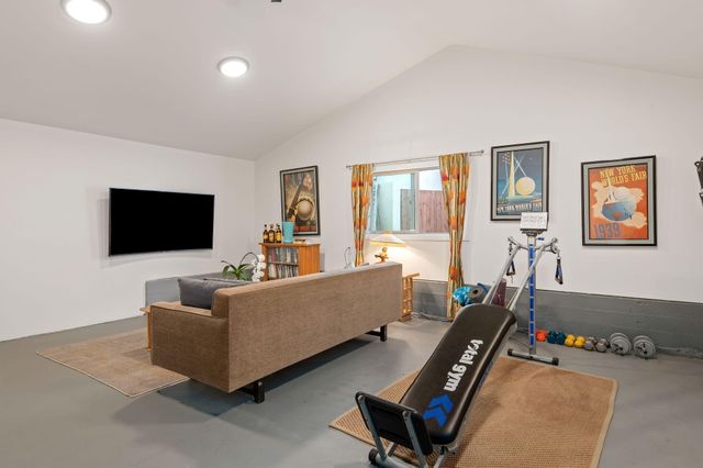 a living room with furniture a flat screen tv and a window