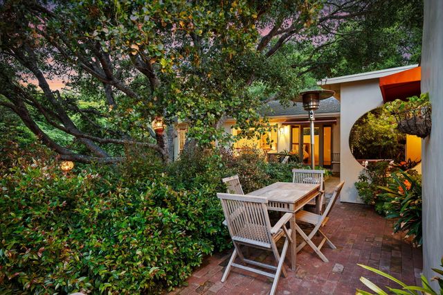 a view of a wooden chairs and table in a backyard