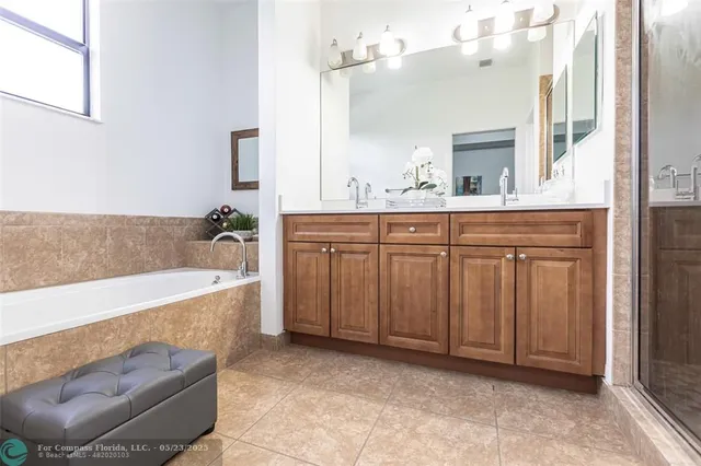 a spacious bathroom with a tub sink and mirror