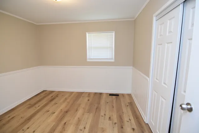 a view of a small space with wooden floor and a window