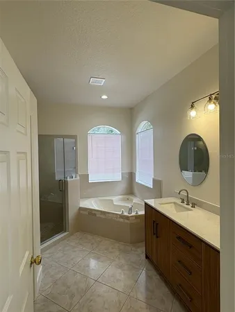 a bathroom with a double vanity sink a mirror and a bathtub