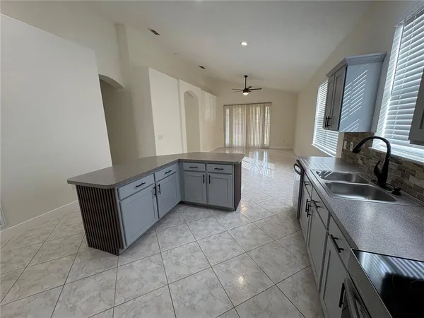 a kitchen with stainless steel appliances a sink a stove a microwave a counter top space and cabinets