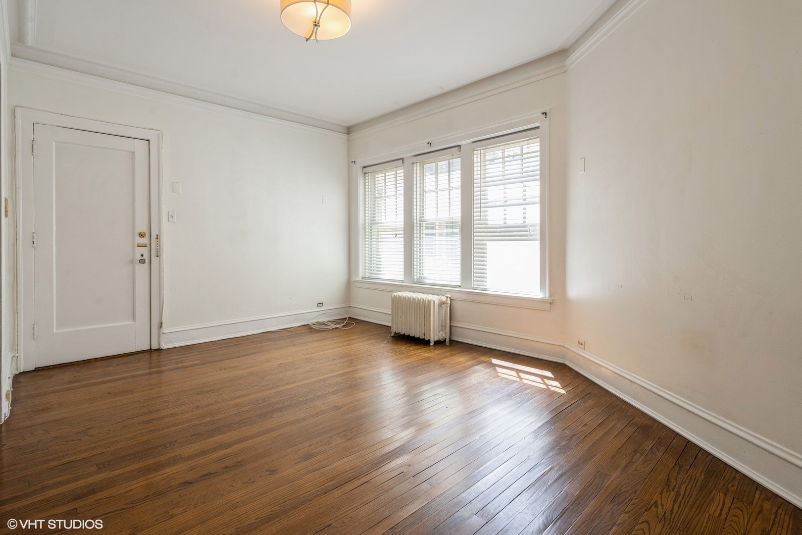 538 West Brompton Avenue, Unit 1W Chicago, IL 60657 - Photo 2 of 16 a view of an empty room with wooden floor and a window