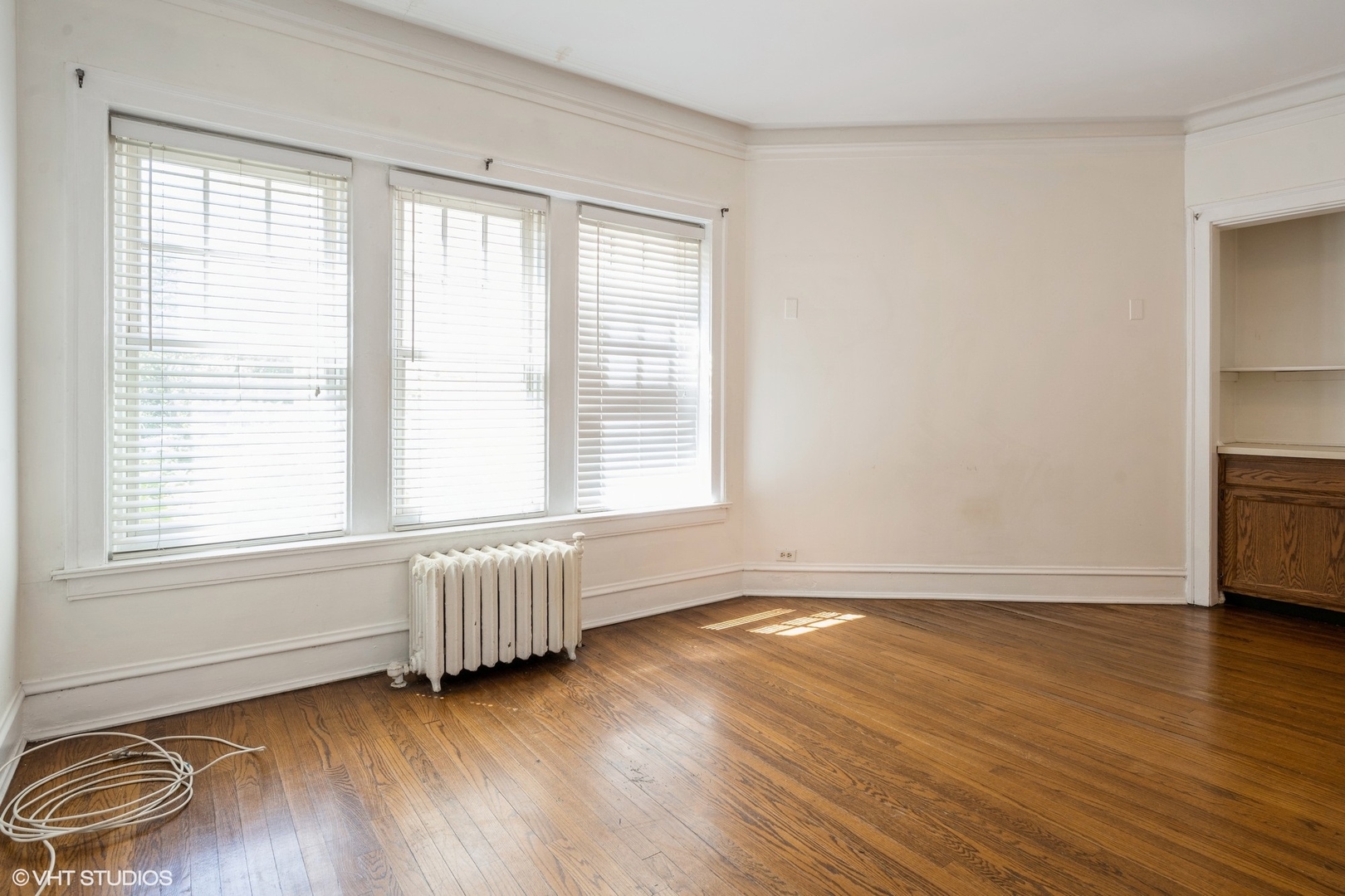 538 West Brompton Avenue, Unit 1W Chicago, IL 60657 - Photo 3 of 16 an empty room with wooden floor and windows
