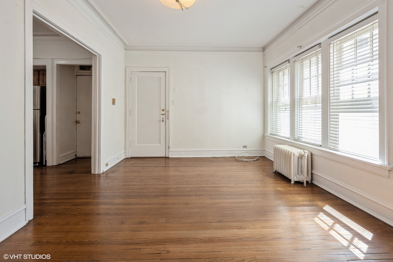 538 West Brompton Avenue, Unit 1W Chicago, IL 60657 - Photo 4 of 16 a view of an empty room with a window and wooden floor